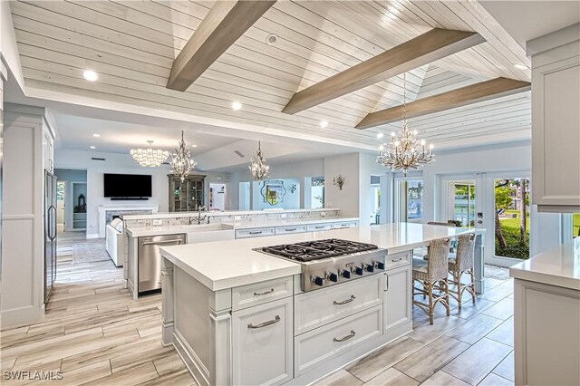 kitchen featuring a spacious island, decorative light fixtures, appliances with stainless steel finishes, and wood ceiling