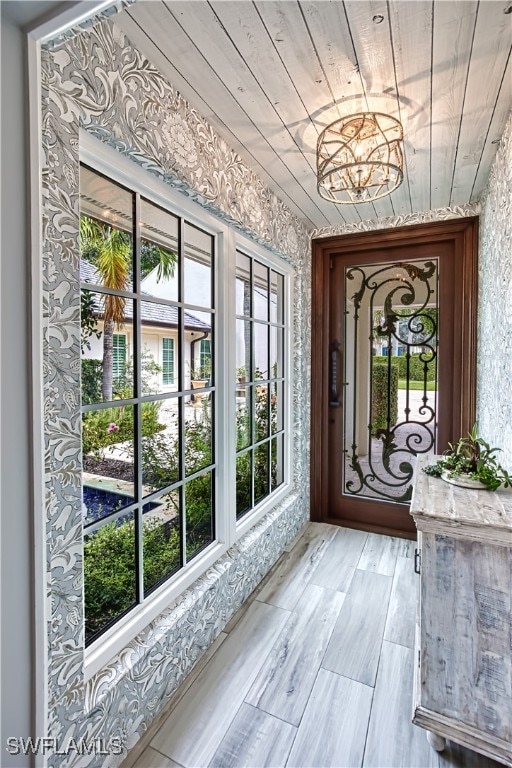 entryway featuring an inviting chandelier, wood ceiling, and light hardwood / wood-style floors