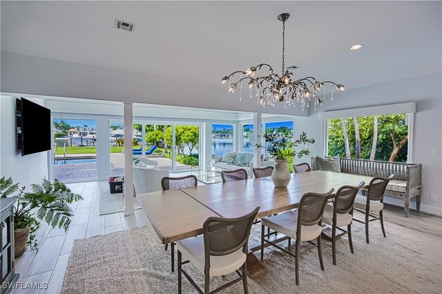 dining area with an inviting chandelier, light hardwood / wood-style flooring, and a healthy amount of sunlight