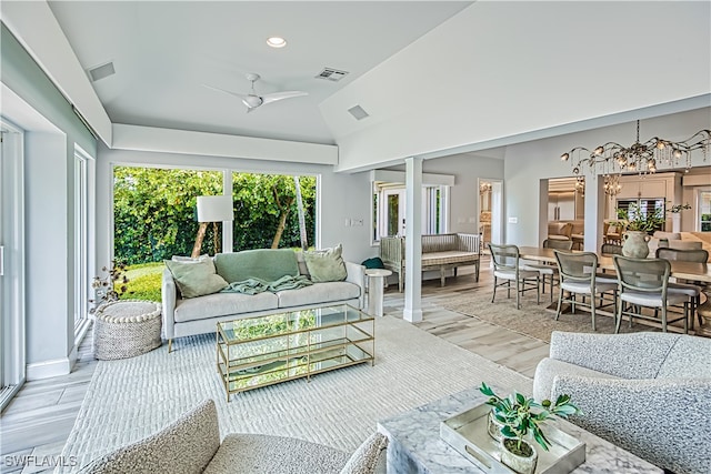 sunroom featuring ceiling fan with notable chandelier and lofted ceiling