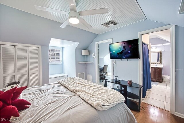 bedroom featuring wood-type flooring, a closet, lofted ceiling, connected bathroom, and ceiling fan