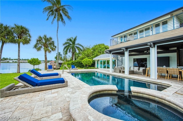 view of pool with ceiling fan, an in ground hot tub, a patio area, an outdoor living space, and a water view