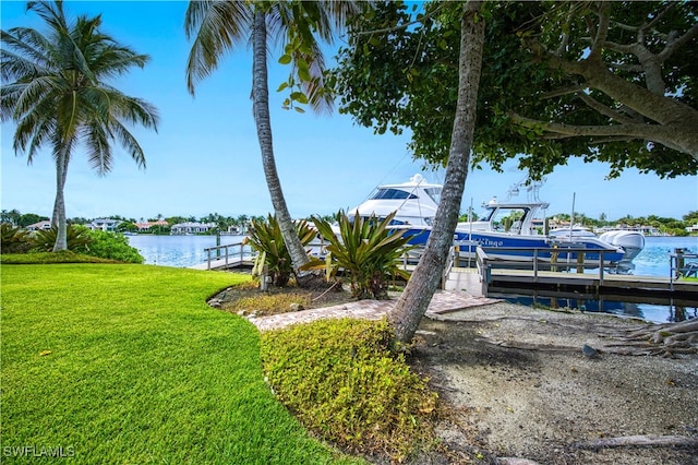 view of dock with a water view and a yard