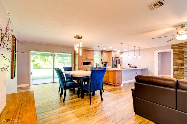 dining space featuring light wood-type flooring and ceiling fan