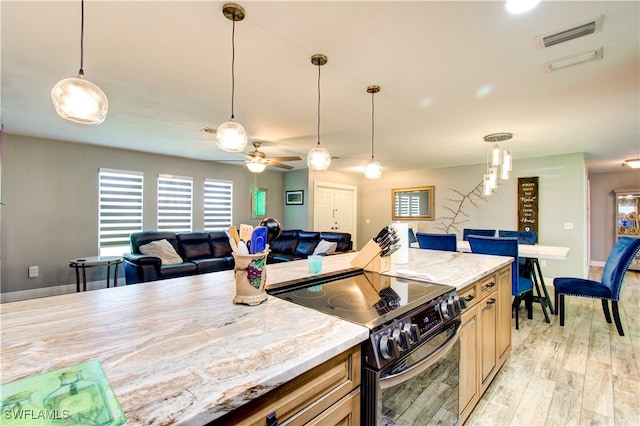 kitchen featuring light wood-type flooring, ceiling fan, stainless steel electric range oven, and decorative light fixtures