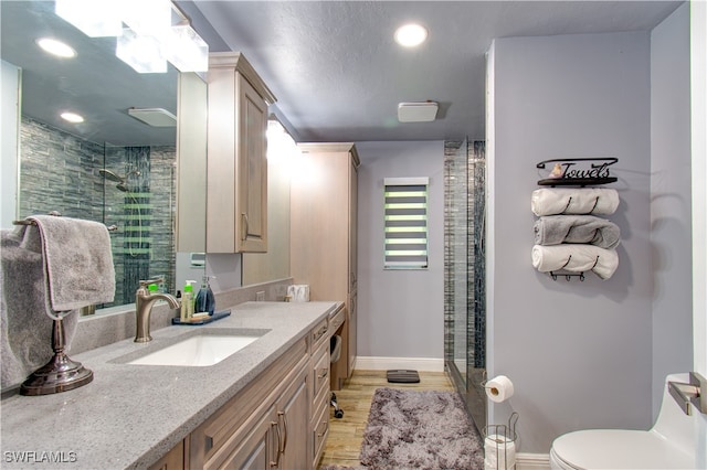 bathroom with vanity, a shower with shower door, toilet, and hardwood / wood-style flooring