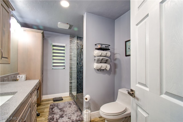 bathroom with vanity, toilet, a shower with door, and hardwood / wood-style flooring