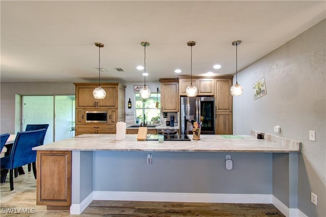 113 SE 41st St, Cape Coral, FL 33904 - kitchen featuring a peninsula, light stone countertops, brown cabinetry, stainless steel appliances, and light wood finished floors