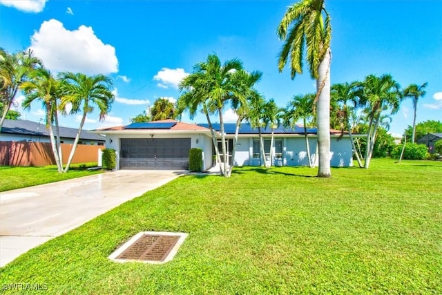 113 SE 41st St, Cape Coral, FL 33904 - single story home with a front yard, roof mounted solar panels, an attached garage, concrete driveway, and stucco siding