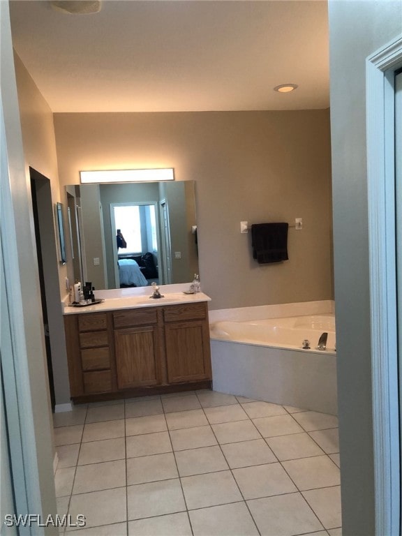 bathroom featuring tile patterned floors, a bathing tub, and vanity