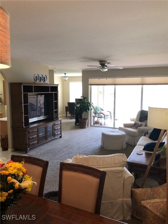 living room with a fireplace, carpet flooring, and ceiling fan