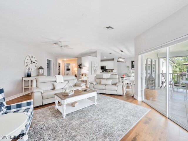 living room with light hardwood / wood-style floors and ceiling fan