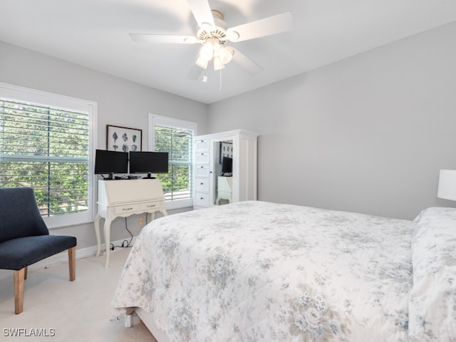 carpeted bedroom with multiple windows and ceiling fan