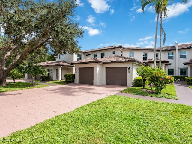 mediterranean / spanish home with a front yard and a garage