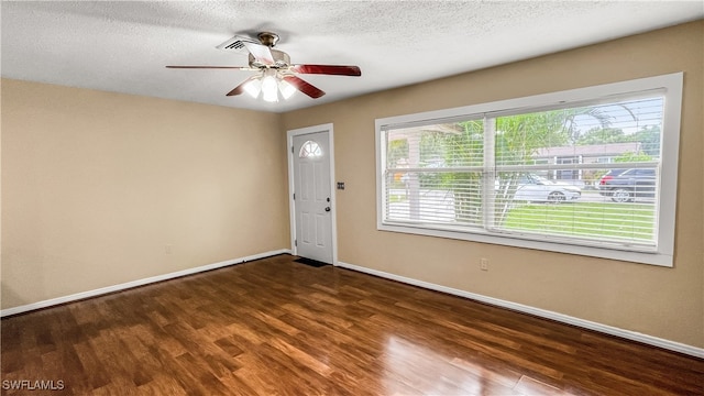 entrance foyer with ceiling fan, dark wood-type flooring, and a healthy amount of sunlight