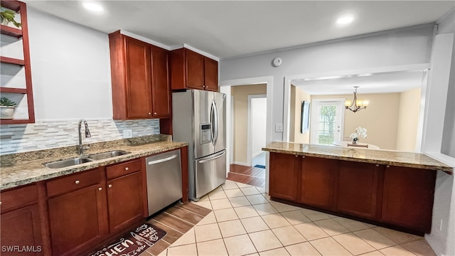 kitchen featuring light stone counters, appliances with stainless steel finishes, and sink