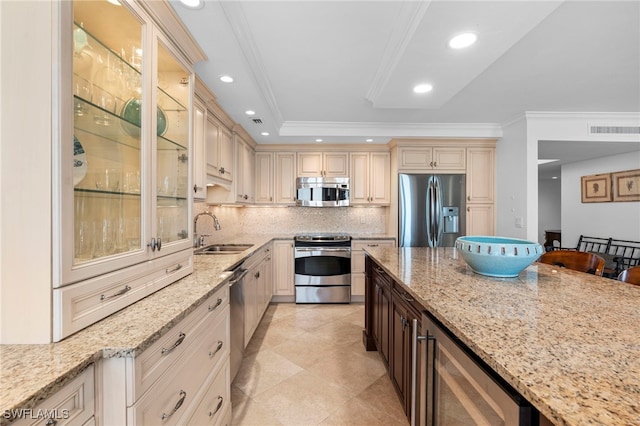 kitchen with wine cooler, tasteful backsplash, light stone counters, sink, and stainless steel appliances