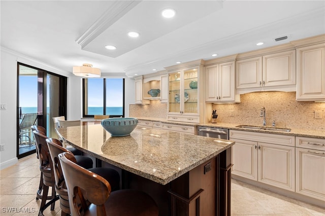 kitchen with sink, a kitchen bar, a water view, and plenty of natural light