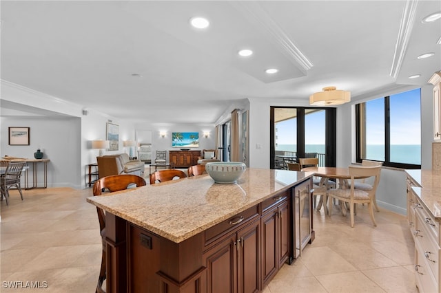 kitchen featuring ornamental molding, light stone countertops, white cabinetry, and light tile patterned floors