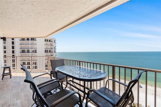 balcony featuring a water view and a beach view