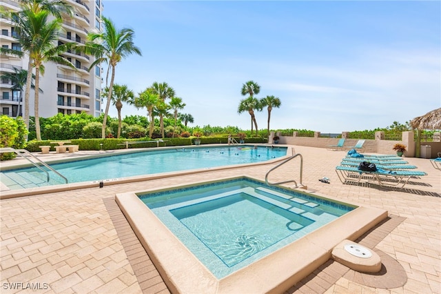 view of pool with a patio area and a community hot tub