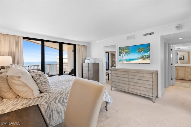 bedroom featuring access to outside, light carpet, ornamental molding, a water view, and ensuite bathroom