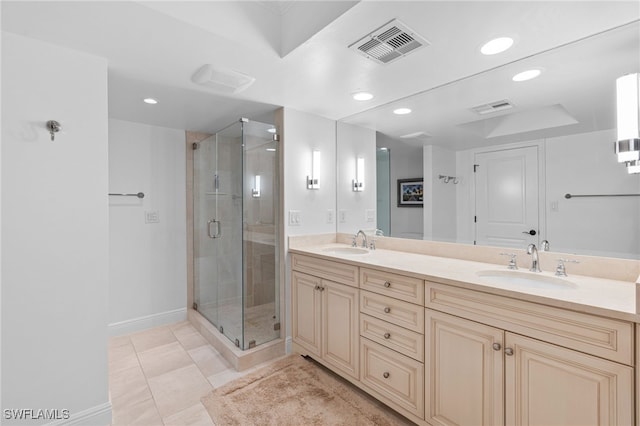 bathroom with a shower with door, vanity, and tile patterned floors