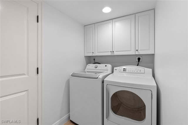 laundry room featuring cabinets and washing machine and clothes dryer