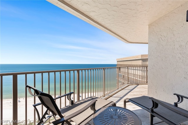 balcony featuring a water view and a view of the beach