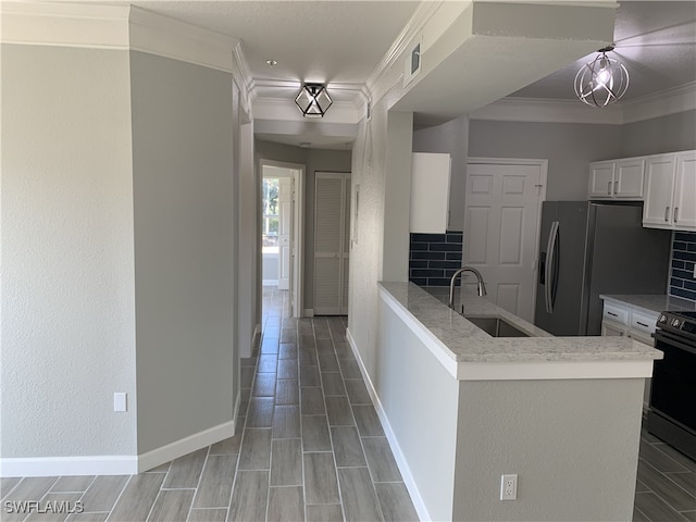 kitchen featuring backsplash, black electric range oven, kitchen peninsula, and white cabinetry