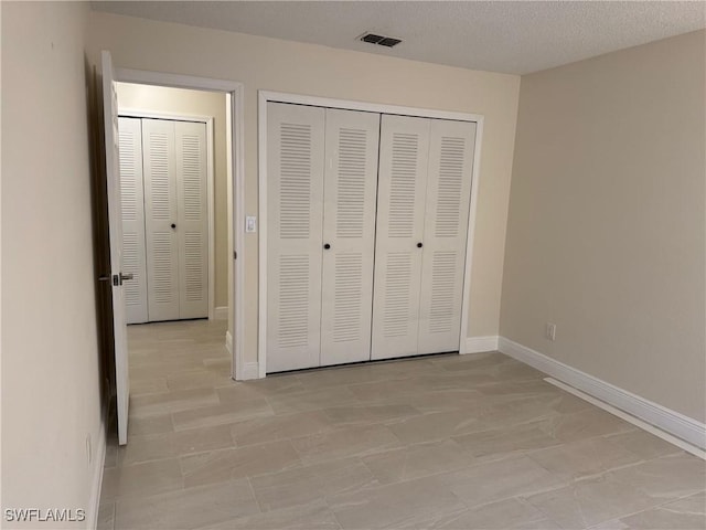 unfurnished bedroom featuring a textured ceiling and a closet