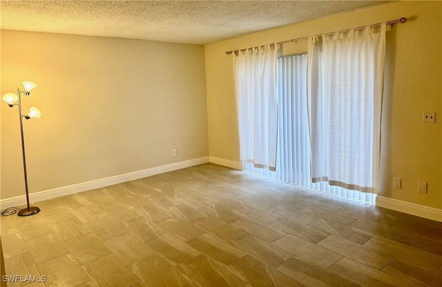 empty room featuring a textured ceiling and plenty of natural light