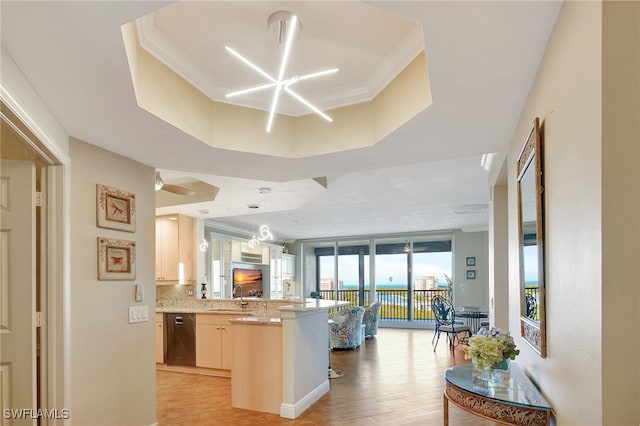 kitchen featuring sink, kitchen peninsula, a breakfast bar area, light wood-type flooring, and decorative backsplash