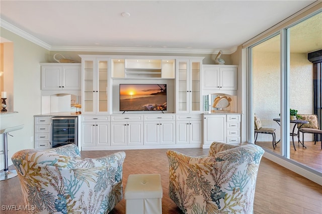 living room featuring crown molding, wine cooler, and light wood-type flooring