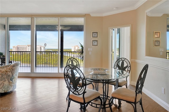 dining area featuring wood-type flooring and crown molding