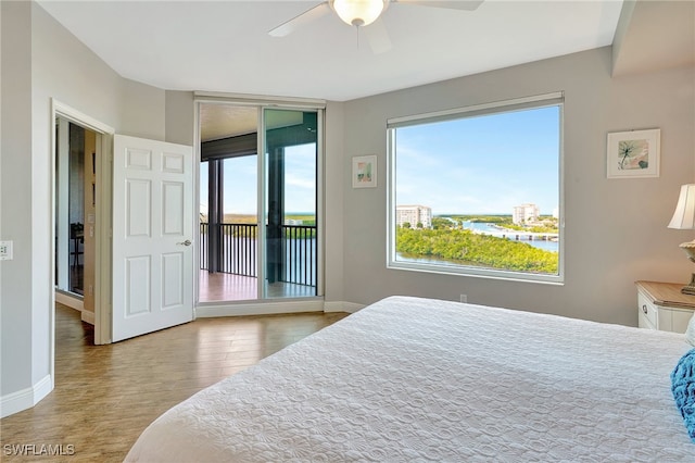 bedroom with light hardwood / wood-style floors, access to exterior, multiple windows, and ceiling fan