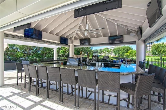 view of patio featuring ceiling fan and exterior bar