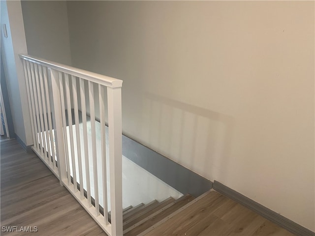 stairs featuring hardwood / wood-style floors