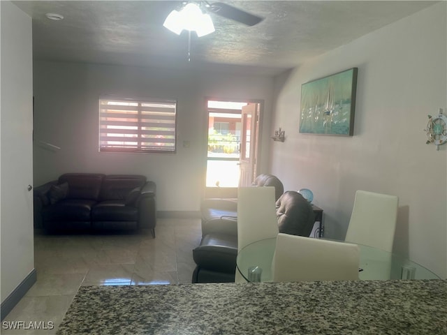 dining room featuring ceiling fan and a textured ceiling