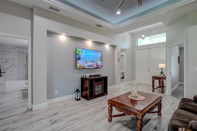 living room featuring light hardwood / wood-style floors, a towering ceiling, and ceiling fan