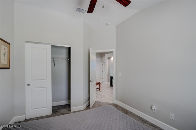 unfurnished bedroom featuring carpet, a closet, lofted ceiling, and ceiling fan