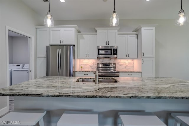 kitchen featuring white cabinetry, pendant lighting, and stainless steel appliances