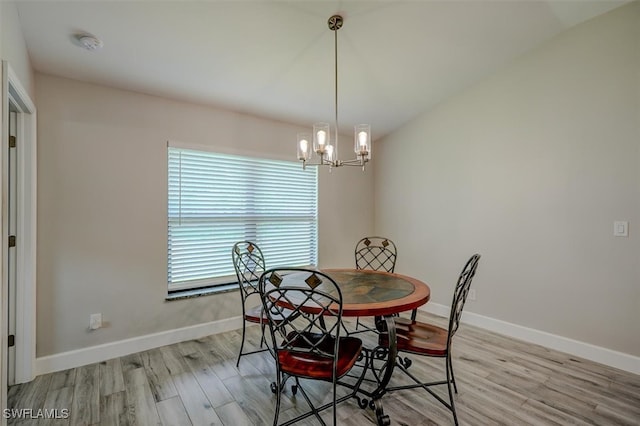 dining area featuring light hardwood / wood-style flooring and a notable chandelier