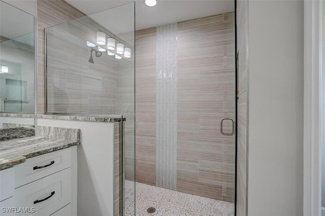 bathroom featuring walk in shower and vanity