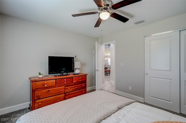 carpeted bedroom with ceiling fan and a closet