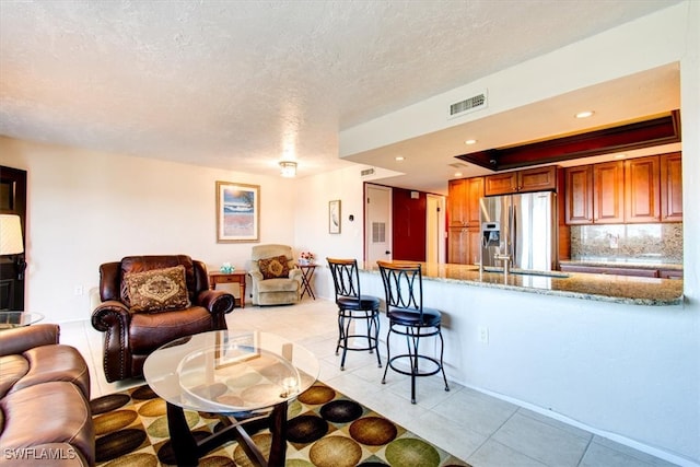 tiled living room with a textured ceiling