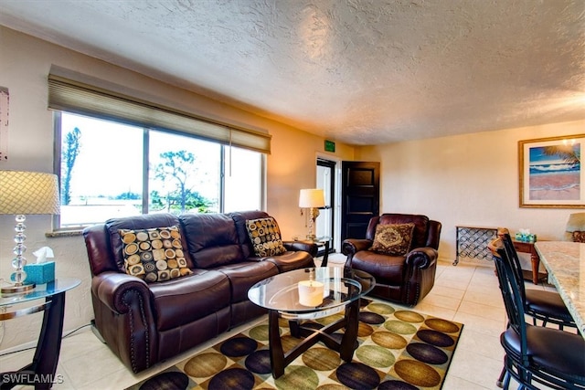 living room with light tile patterned flooring and a textured ceiling