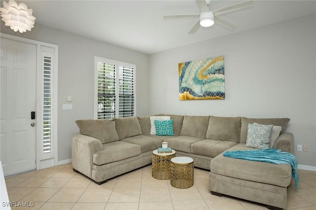 living room with light tile patterned floors, ceiling fan, and baseboards