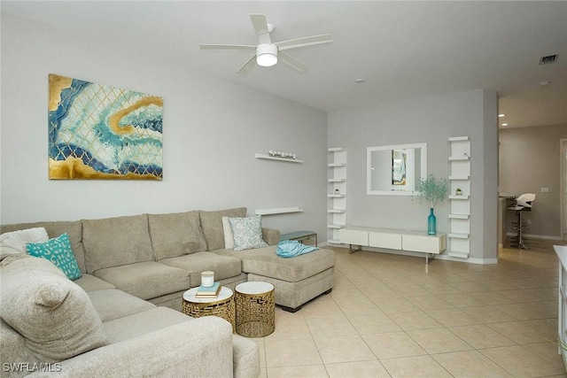 living room with a ceiling fan, visible vents, and light tile patterned floors