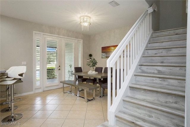 interior space featuring baseboards, visible vents, stairs, and light tile patterned floors